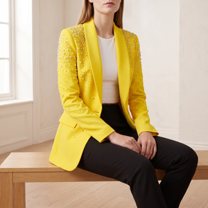Adrienne pearl detail blazer in Yellow worn seated on an oak bench