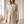 Close view of the Agathe long double breasted coat in Cream from the front, showing the tie belt and flap pockets