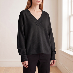 Annabel cashmere V neck sweater in Black worn by a window in a bright room