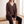 Annabel cashmere V neck sweater in Brown worn seated on a pale oak bench