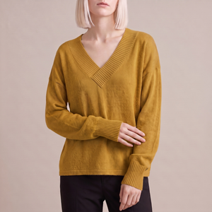Annabel cashmere V neck sweater in Mustard on a light gray studio backdrop