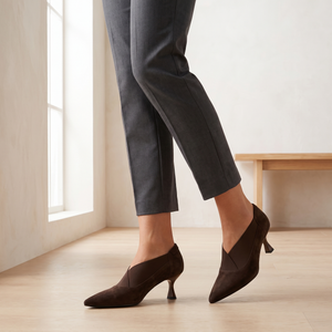 Ariane suede kitten heel pumps in Brown worn by a window in a bright room with a pale oak floor