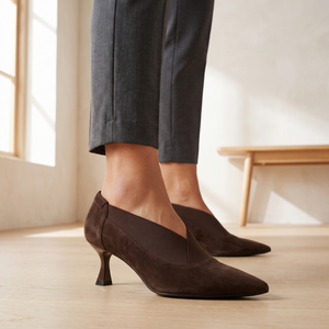 Close view of the Ariane pump in Brown showing the pointed toe, V shaped elastic gore and kitten heel