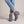 Beatrice suede ankle boots in Blue with one foot crossed over the other on a light gray studio backdrop