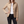 Belinda quilted jacket in Beige with one hand on the hip on a light gray studio backdrop
