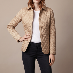 Belinda quilted jacket in Beige with one hand on the hip on a light gray studio backdrop