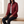 Belinda quilted jacket in Dark Red worn seated on an oak bench
