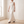 Cecily one shoulder satin maxi dress in White walking across a bright room