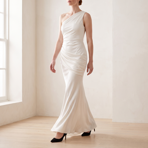 Cecily one shoulder satin maxi dress in White walking across a bright room