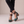 Clarisse block heel pumps in Green Snake Print worn with ankles crossed on a light gray studio backdrop