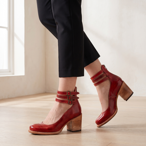 Clarisse block heel pumps in Red worn mid step by a window