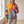 Clemency patchwork sun hoodie worn by a window, holding a drawstring