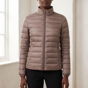 Close view of the Clementine quilted down jacket in Taupe showing the front zip, quilting and zipped side pocket