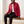 Clementine quilted down jacket in Red worn open, seated on an oak bench