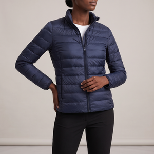 Clementine quilted down jacket in Navy Blue on a light gray studio backdrop