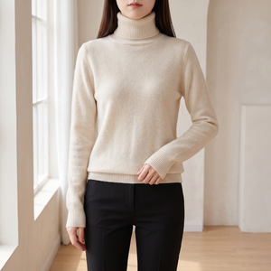 Cressida cashmere turtleneck sweater in Ivory worn by a window in a bright room