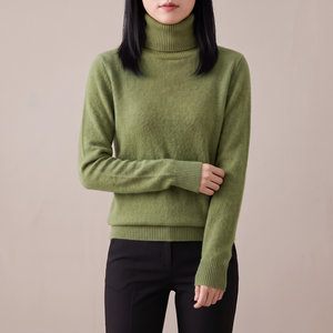 Cressida cashmere turtleneck sweater in Olive on a light gray studio backdrop