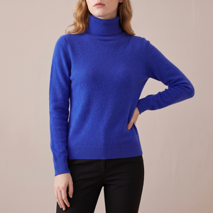 Cressida cashmere turtleneck sweater in Royal Blue on a light gray studio backdrop