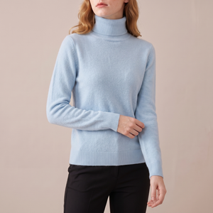 Cressida cashmere turtleneck sweater in Sky Blue on a light gray studio backdrop