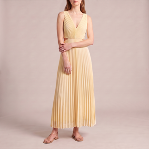 Cristina pleated maxi dress in Yellow on a light gray studio backdrop