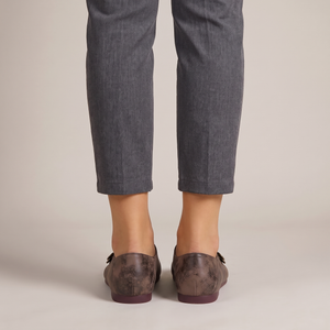 Elinor round toe flats in Dark Brown worn with cropped gray trousers on a light gray studio backdrop