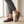 Elinor round toe flats in Dark Brown worn with cropped gray trousers on a pale oak floor by a window