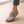 Close view of the cords and brass tone buttons on the Elinor round toe flats in Taupe