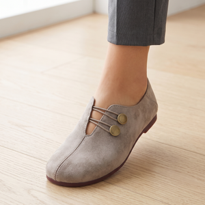 Close view of the cords and brass tone buttons on the Elinor round toe flats in Taupe