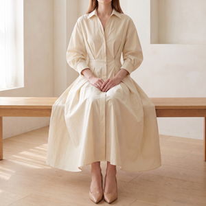 Eliza maxi shirt dress in Cream worn seated on a pale oak bench