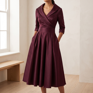 Woman by a window in the Wine Eloise midi dress with her hands in the side pockets