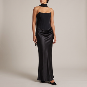 Faustine strapless maxi dress in Black with a sheer scarf at the neck on a light gray studio backdrop