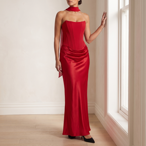 Faustine strapless maxi dress in Red, full length, standing by a window
