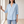 Francesca linen blend button down shirt in Blue, standing by a window in a bright room