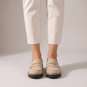 Gloria suede penny loafers in Beige seen from the front on a light gray studio backdrop