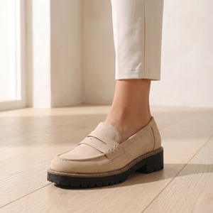 Close view of the penny strap, moc toe and stitched welt on the Gloria suede penny loafers in Beige