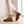 Gloria suede penny loafers in Brown mid stride on an oak floor, showing the lug sole