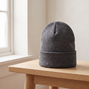 Hattie knit beanie in Gray on an oak bench showing the deep folded cuff