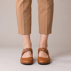 Hortense leather Mary Jane pumps in Cognac on a light gray studio backdrop
