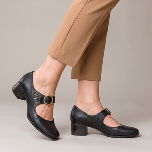 Hortense leather Mary Jane pumps in Black with cropped camel trousers on a light gray studio backdrop