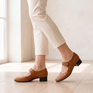 Hortense leather Mary Jane pumps in Cognac, walking on an oak floor