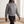 Imelda nylon bomber jacket in Gray zipped up, walking across a bright room