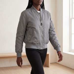 Imelda nylon bomber jacket in Gray zipped up, walking across a bright room