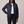 Imelda nylon bomber jacket in Navy Blue with one hand on the hip on a light gray studio backdrop