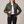 Imelda nylon bomber jacket in Olive Green worn open with one hand on the hip on a light gray studio backdrop