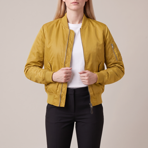 Imelda nylon bomber jacket in Yellow worn open with both hands at the front edges on a light gray studio backdrop