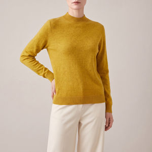 Imogen cashmere mock neck sweater in Mustard worn with cream wide leg trousers