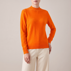 Imogen cashmere mock neck sweater in Orange worn with cream wide leg trousers