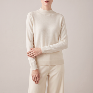 Imogen cashmere mock neck sweater in White worn with cream wide leg trousers