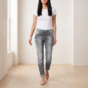 Irene skinny jeans in Gray worn walking across a bright room, showing the diagonal leg seams
