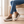 Laetitia canvas platform sneakers in Tiger Print worn while seated on an oak bench
